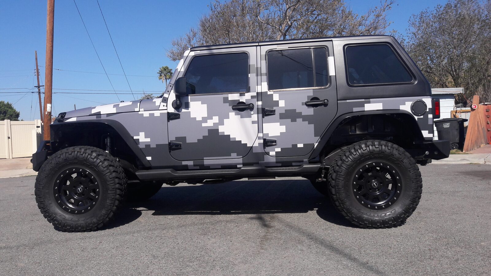 Camouflage Jeep Wrangler JKU with black fastback hard top installed