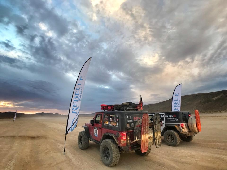 Red Jeep Wrangler JK 2 Door with regular hard top at an off-road event