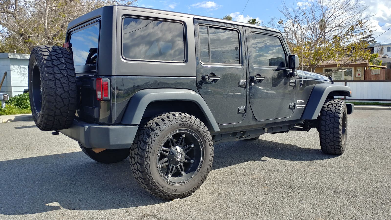 Gray Jeep Wrangler JKU with black hard top installed