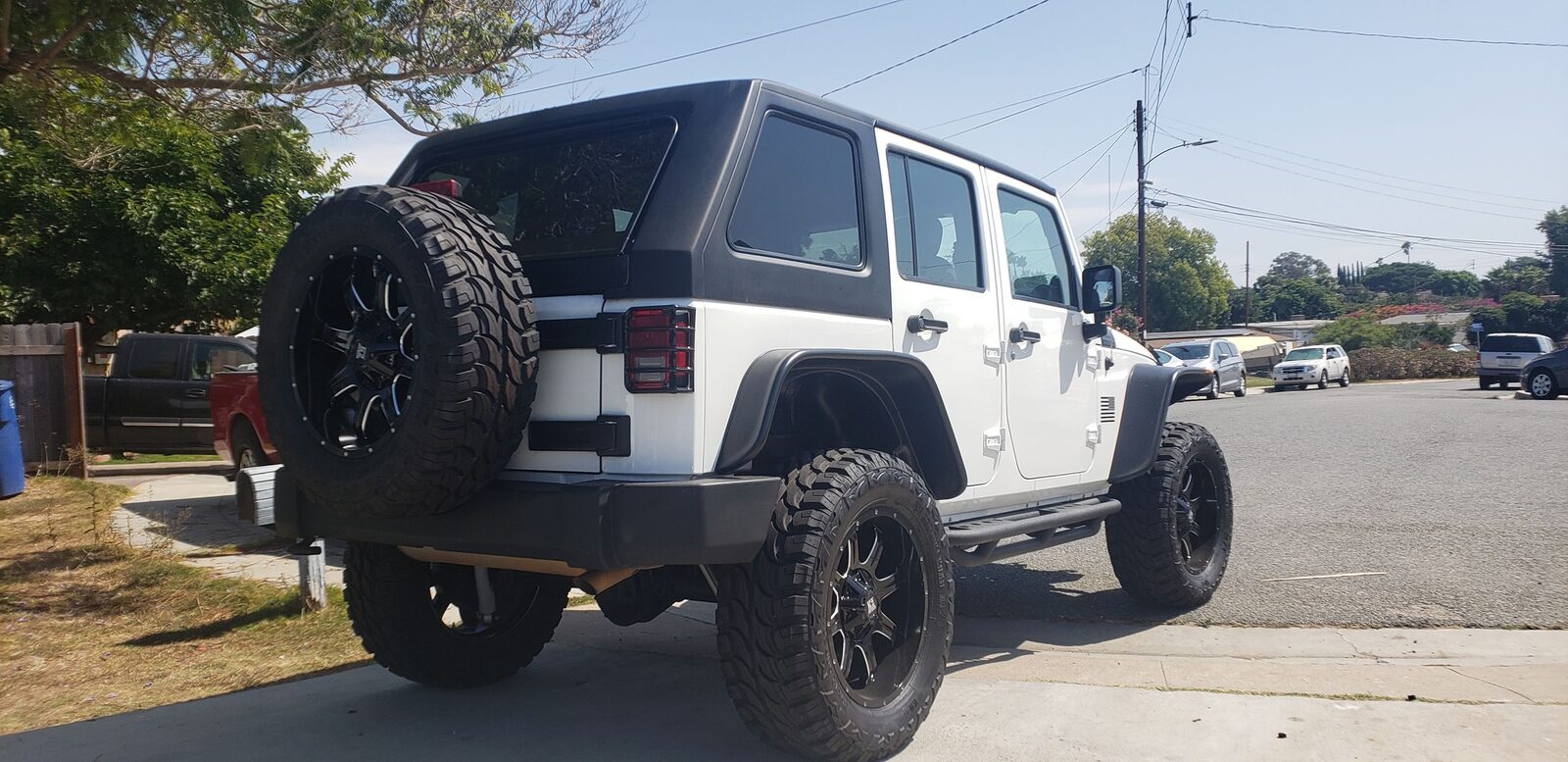 White Jeep Wrangler JKU with black fastback hard top viewed from the rear