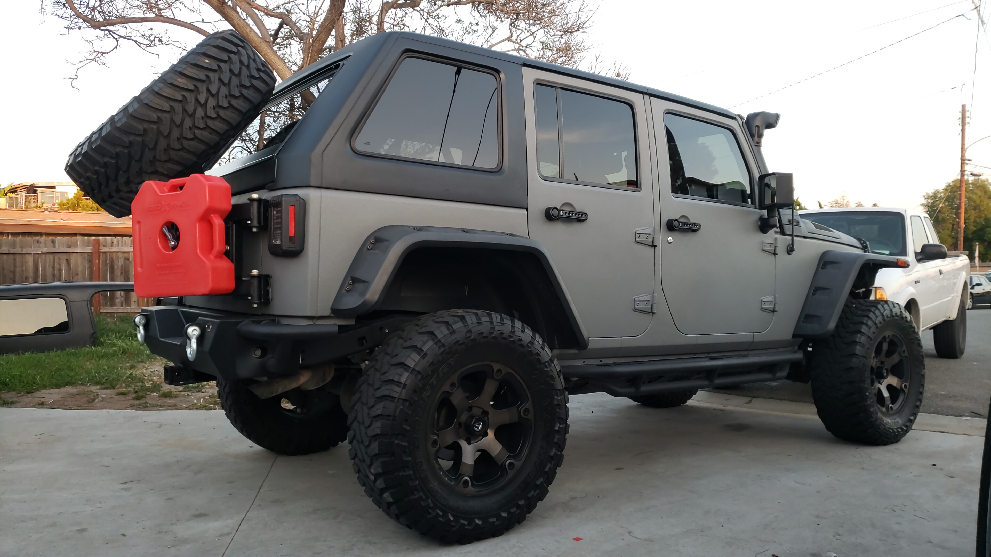 Gray Jeep Wrangler JKU with Camper King USA fastback hard top installed